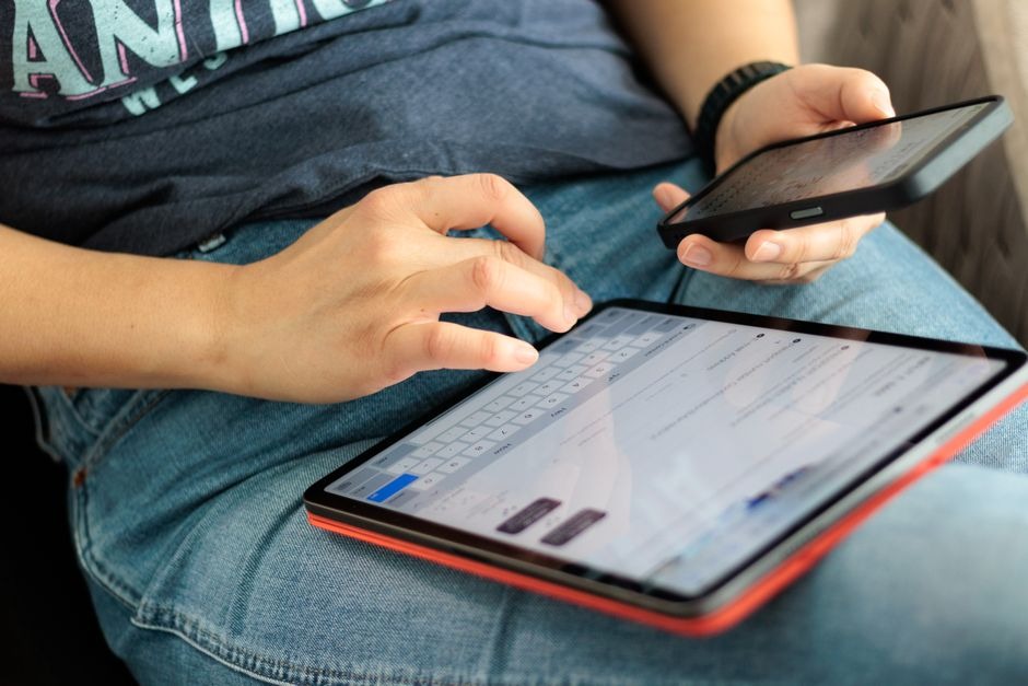 Person working on tablet and smartphone