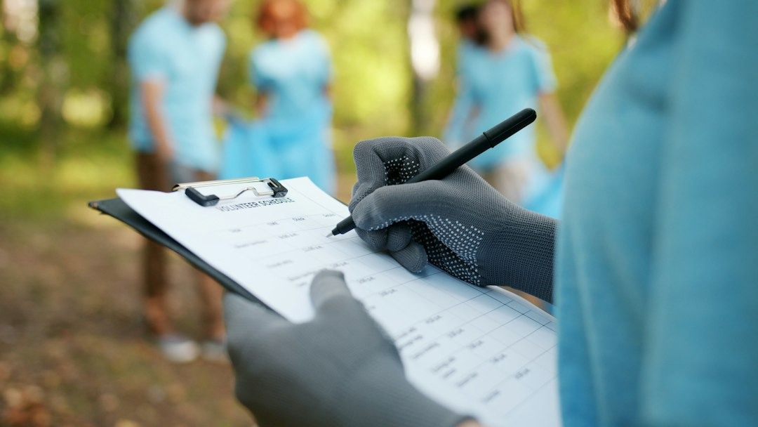 person writing on a clipboard