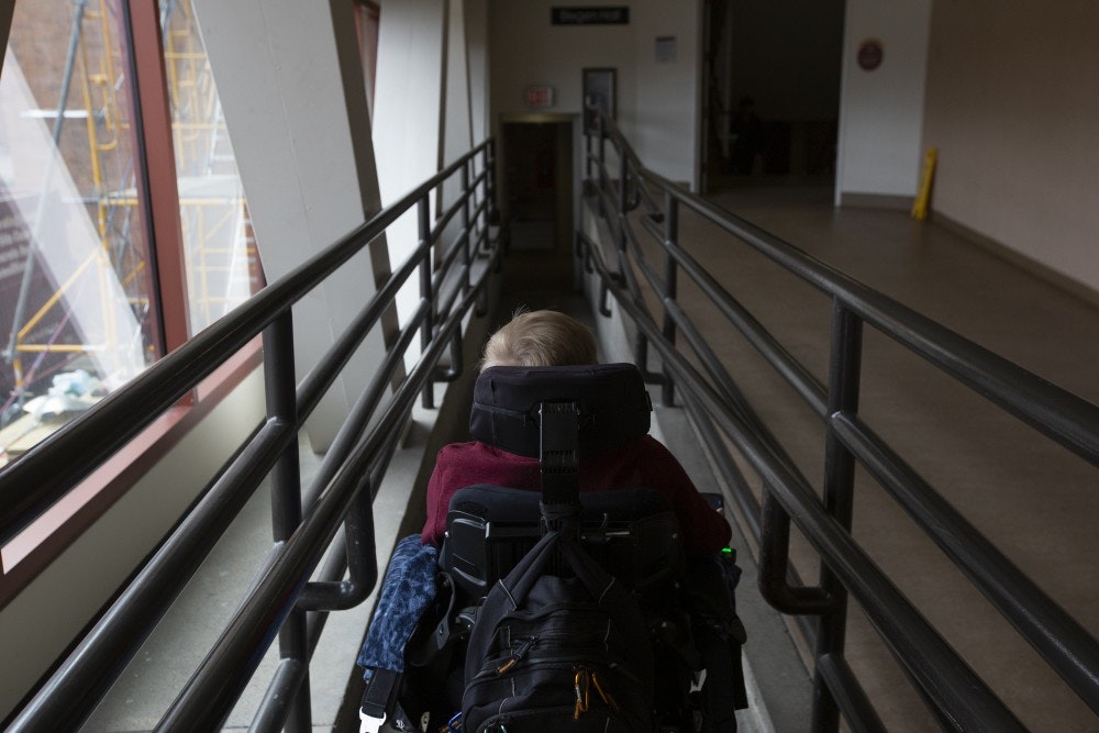 Student with disability travels down the ramp that leads to Blegen Hall