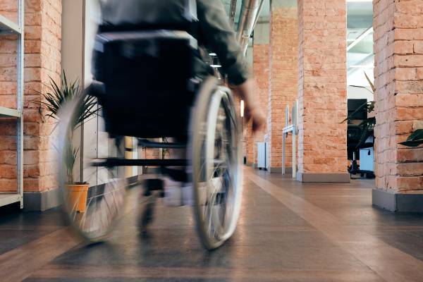 Image of person in wheelchair moving through a corridor