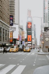 Image of vehicles traveling on road near buildings during daytime in New York City